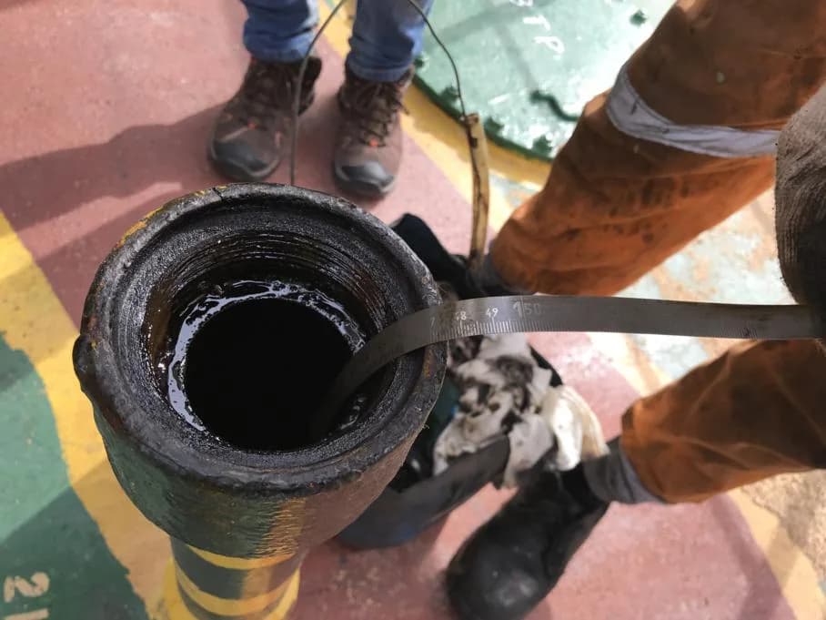 Surveyor measuring fuel inside a bunker tank.