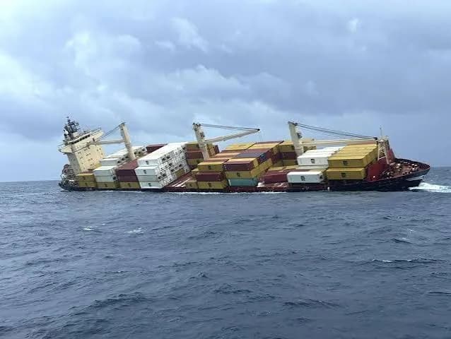 Cargo vessel listing in rough water during an environmental damage survey.