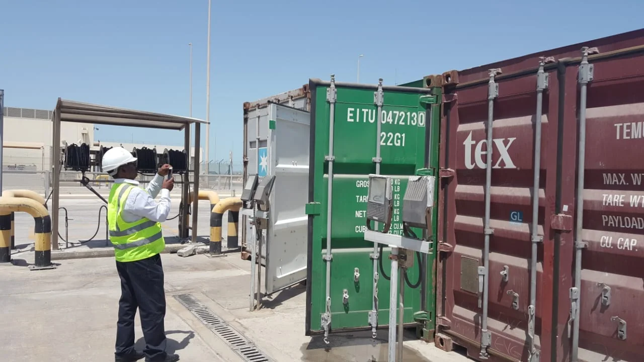 Surveyor photographing the doors of a freight container.
