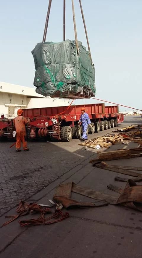 Covered industrial cargo suspended above a heavy transport trailer.