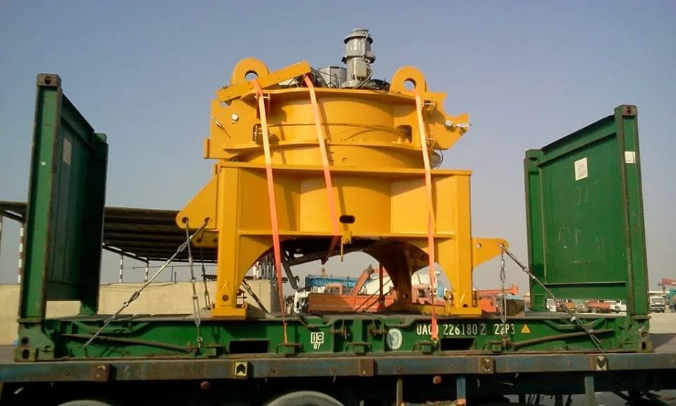 Large yellow industrial machine secured on an open transport platform.