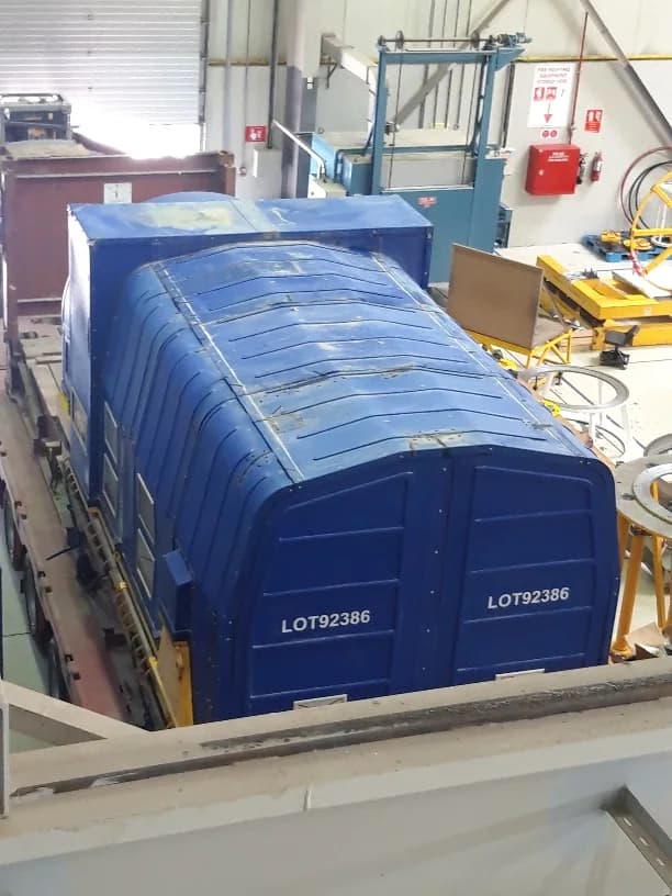Blue covered industrial equipment inside a cargo facility.