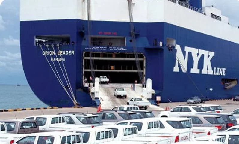 Vehicles moving at the open ramp of a roll-on roll-off ship.
