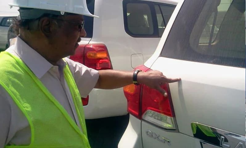 Surveyor inspecting the rear of a vehicle.