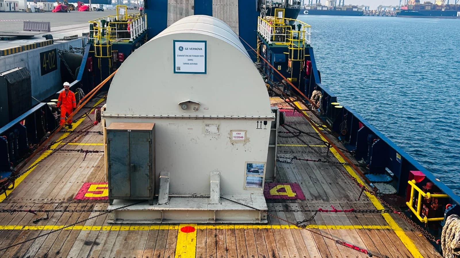 Large industrial cargo secured with chains on a barge.